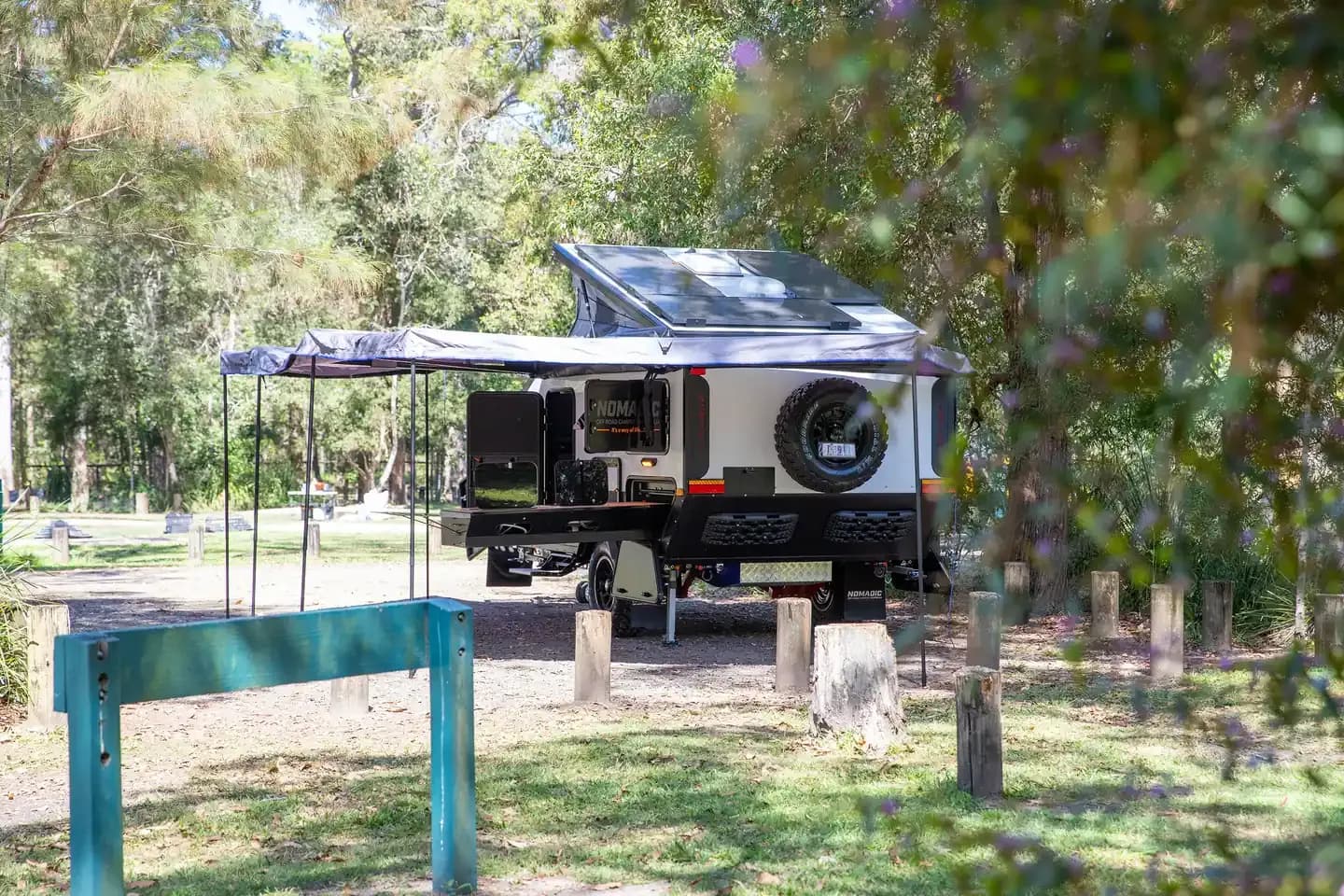Nomadic pod camper set up at camp with the awning out